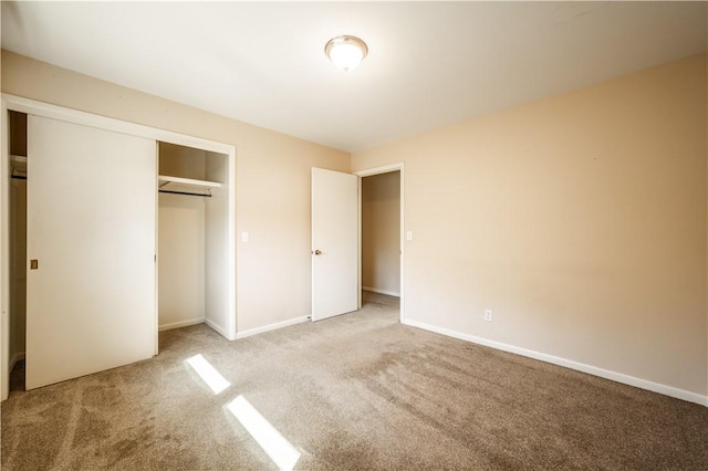 unfurnished bedroom with carpet floors, baseboards, and a closet