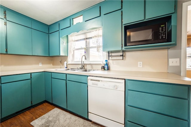 kitchen with dark wood finished floors, white dishwasher, light countertops, black microwave, and a sink