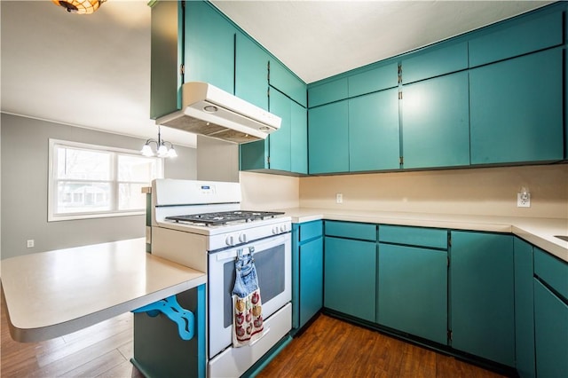 kitchen featuring dark wood-style flooring, an inviting chandelier, white gas range, light countertops, and under cabinet range hood