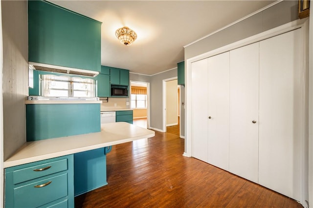 kitchen featuring black microwave, white dishwasher, light countertops, dark wood finished floors, and green cabinetry