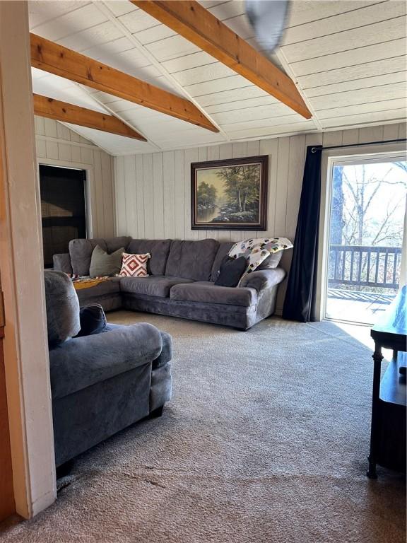 living room featuring vaulted ceiling with beams and carpet flooring