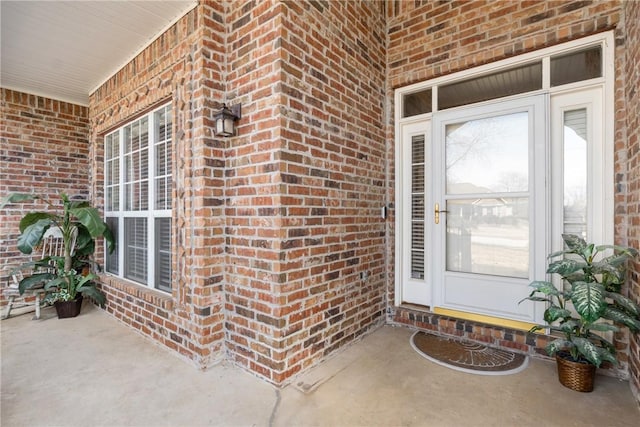 view of exterior entry featuring brick siding