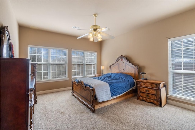 carpeted bedroom with visible vents, baseboards, and a ceiling fan