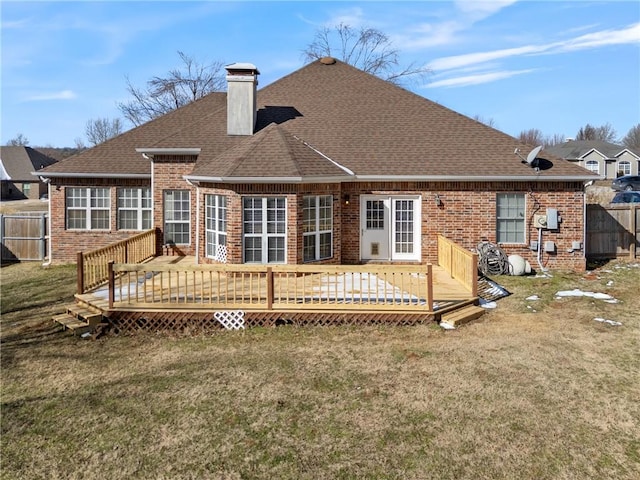 back of house featuring brick siding, a yard, and a chimney