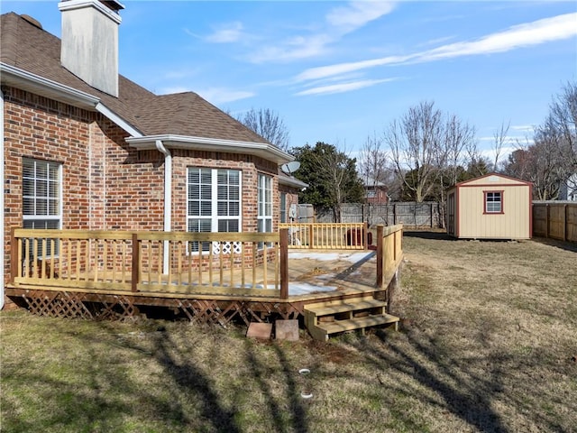 wooden deck with a yard, a fenced backyard, a storage shed, and an outbuilding