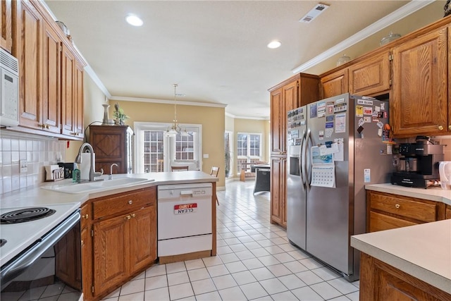 kitchen with white appliances, visible vents, a peninsula, light countertops, and a sink