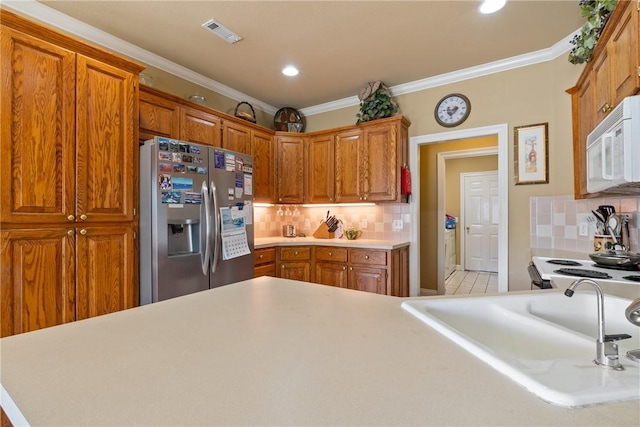 kitchen featuring white appliances, visible vents, a sink, and ornamental molding