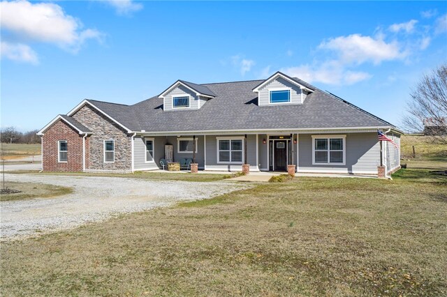 view of front of home with covered porch, a front lawn, and a shingled roof