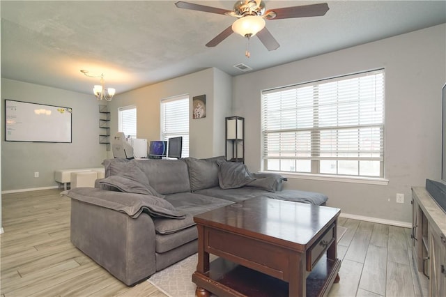 living area featuring a healthy amount of sunlight, light wood-style floors, baseboards, and visible vents