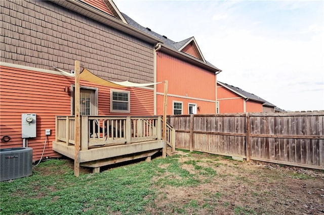 rear view of property featuring a yard, central AC, fence, and a wooden deck