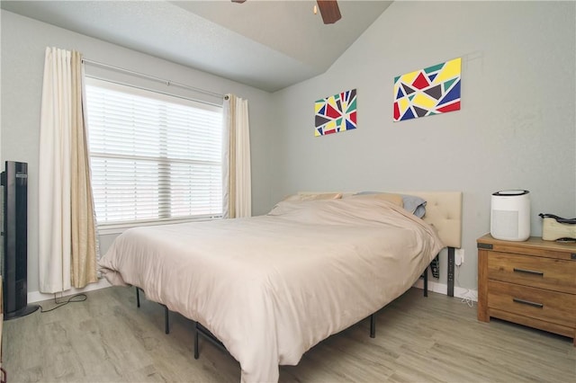 bedroom featuring lofted ceiling, a ceiling fan, and wood finished floors