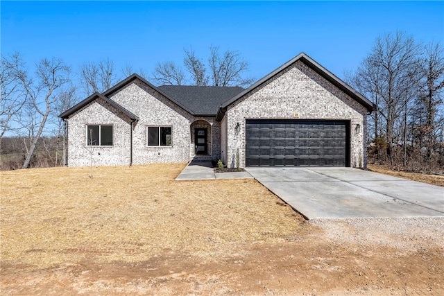 view of front of house with concrete driveway, an attached garage, brick siding, and a front lawn