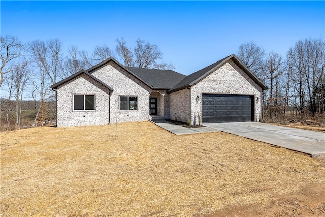 view of front of home with driveway, a garage, a front lawn, and brick siding