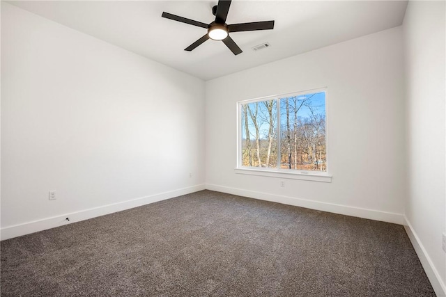 spare room featuring a ceiling fan, dark colored carpet, visible vents, and baseboards