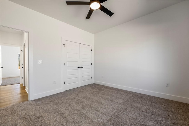 unfurnished bedroom featuring carpet, baseboards, ceiling fan, and a closet