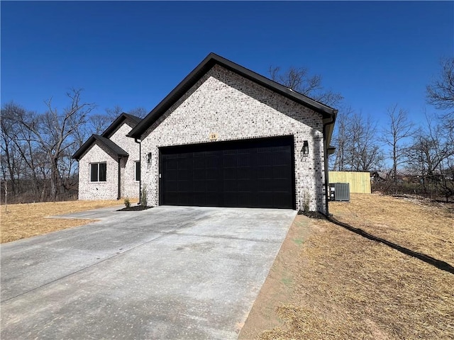 view of front of house featuring brick siding, an attached garage, central AC unit, and driveway