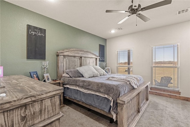 bedroom with a ceiling fan, visible vents, a textured wall, and carpet flooring