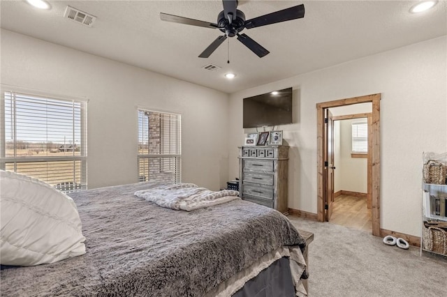 bedroom with recessed lighting, visible vents, light carpet, and baseboards