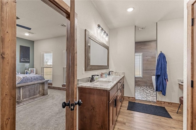 full bathroom featuring visible vents, walk in shower, wood finished floors, and vanity