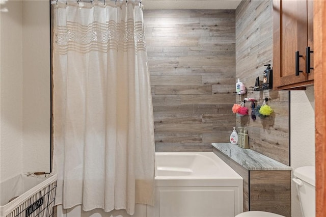 full bathroom with toilet, wood walls, and shower / bathtub combination with curtain