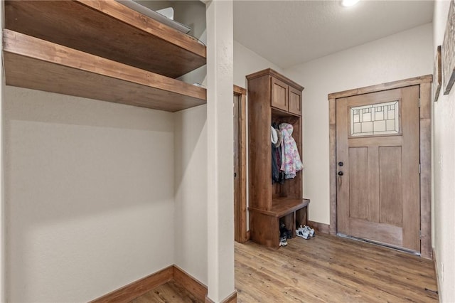 mudroom featuring light wood-style flooring and baseboards