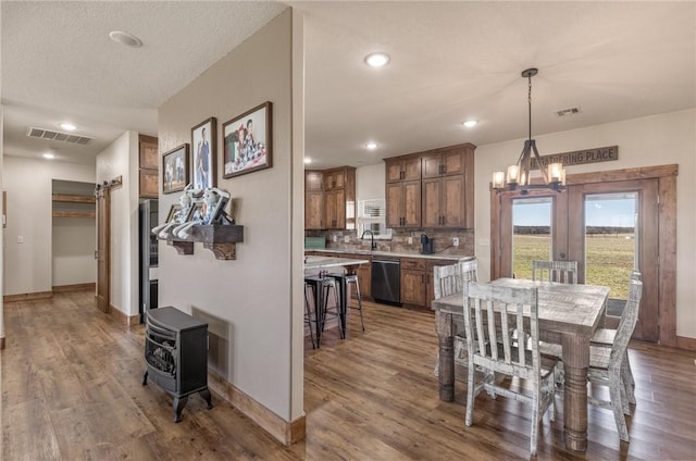 dining space with visible vents, baseboards, and wood finished floors