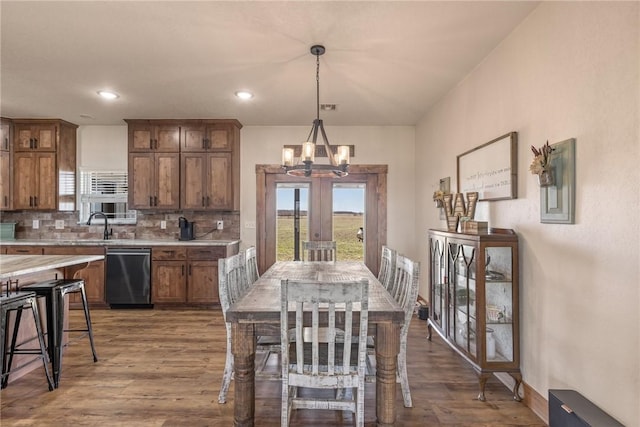 kitchen with dark wood-style floors, light countertops, stainless steel dishwasher, and decorative backsplash