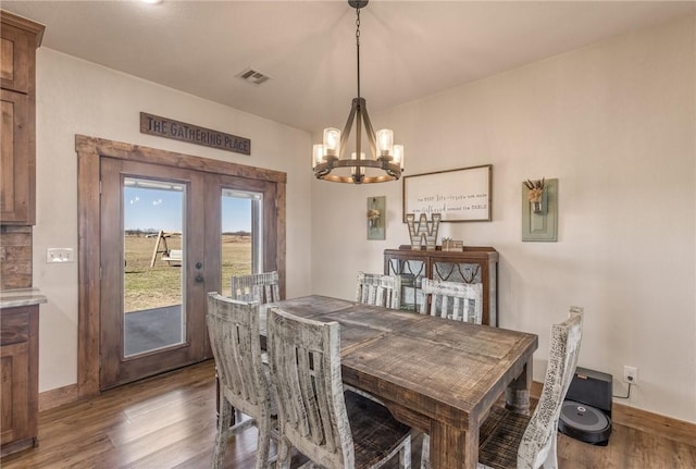 dining space with french doors, visible vents, baseboards, and wood finished floors