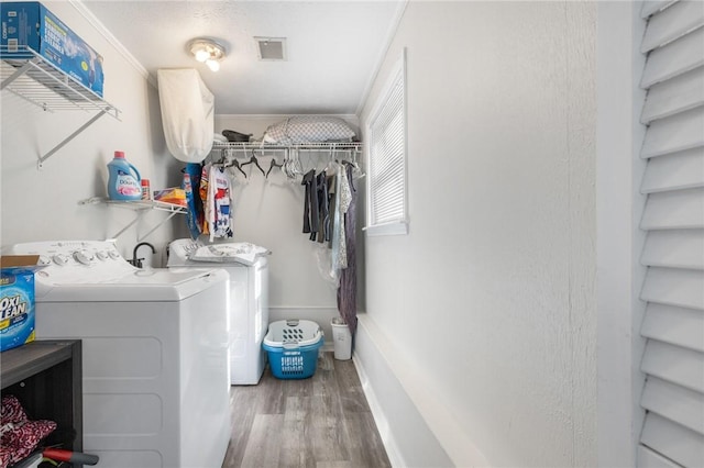 washroom with laundry area, visible vents, wood finished floors, and independent washer and dryer