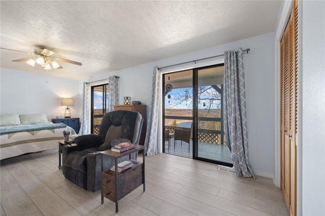 bedroom featuring access to outside, a ceiling fan, and a textured ceiling