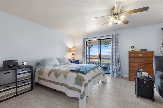 bedroom with access to exterior, a ceiling fan, light wood finished floors, and a textured ceiling