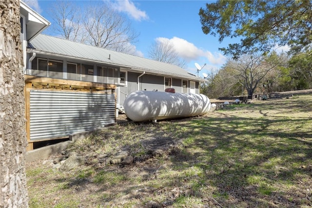 rear view of property with a sunroom and metal roof