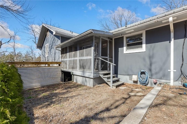 view of home's exterior with entry steps and a sunroom