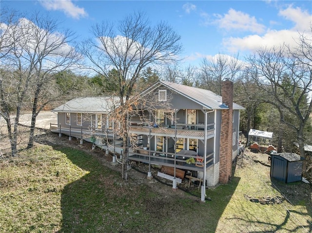 rear view of property with a chimney and a wooden deck