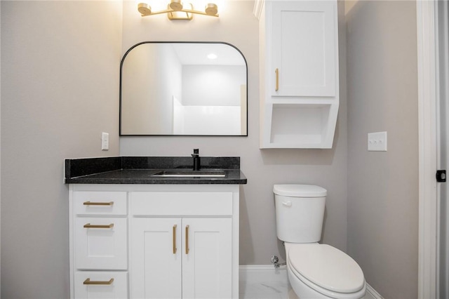 half bathroom featuring toilet, marble finish floor, vanity, and baseboards