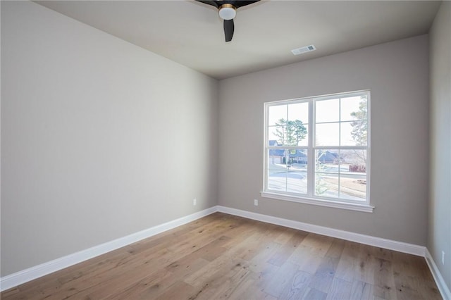 unfurnished room featuring a ceiling fan, baseboards, visible vents, and light wood finished floors