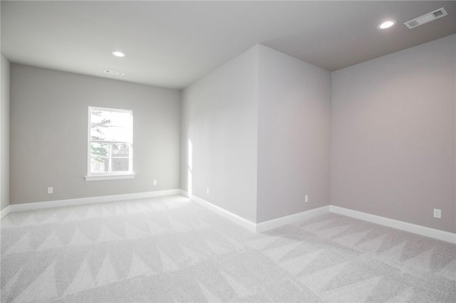 empty room featuring light colored carpet, visible vents, and recessed lighting