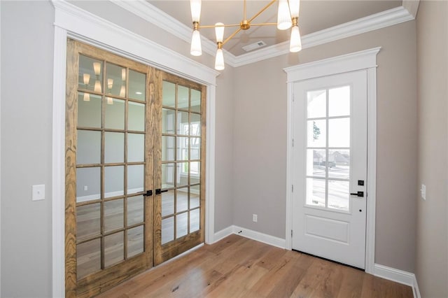 doorway featuring ornamental molding, french doors, baseboards, and wood finished floors