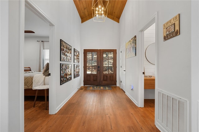 foyer featuring wooden ceiling, visible vents, light wood finished floors, and french doors