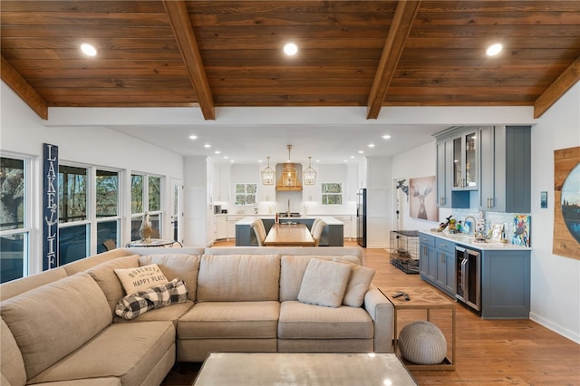 living room featuring beverage cooler, lofted ceiling with beams, and indoor wet bar