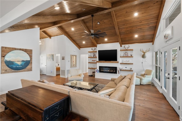 living room featuring wooden ceiling, high vaulted ceiling, wood finished floors, and a glass covered fireplace