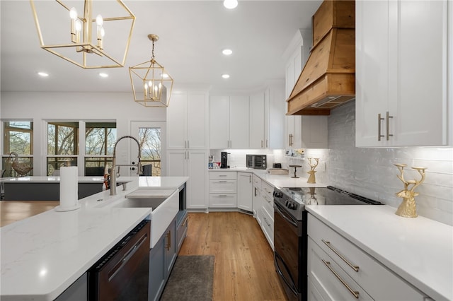 kitchen with dishwashing machine, a sink, white cabinetry, black electric range oven, and custom range hood