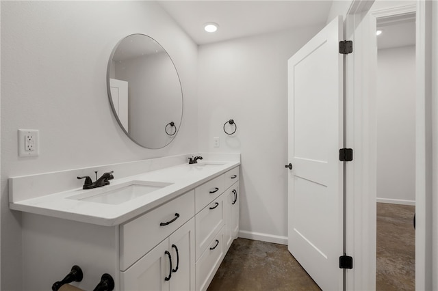 bathroom featuring concrete floors, a sink, baseboards, and double vanity