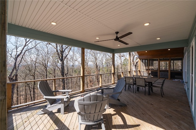 deck with outdoor dining area and a ceiling fan