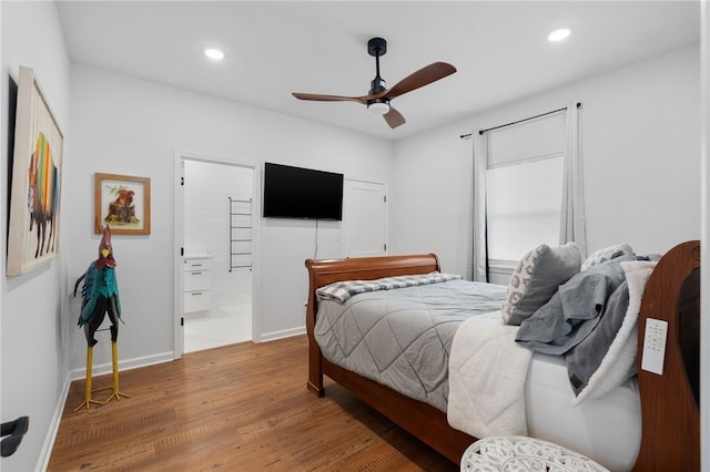 bedroom featuring connected bathroom, baseboards, wood finished floors, and recessed lighting