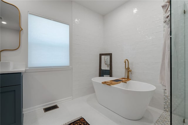 bathroom featuring visible vents, a tile shower, vanity, a freestanding tub, and tile patterned floors