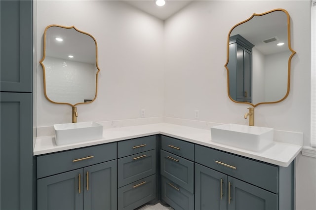 full bath with double vanity, visible vents, a sink, and recessed lighting