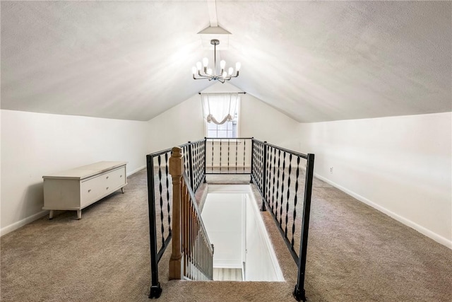 interior space featuring a textured ceiling, carpet, baseboards, and an inviting chandelier