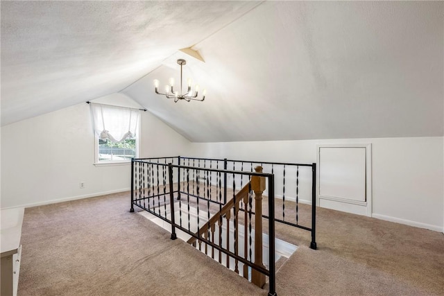 additional living space featuring carpet floors, baseboards, a notable chandelier, and lofted ceiling