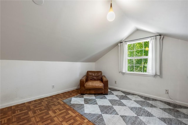 unfurnished room featuring baseboards and vaulted ceiling